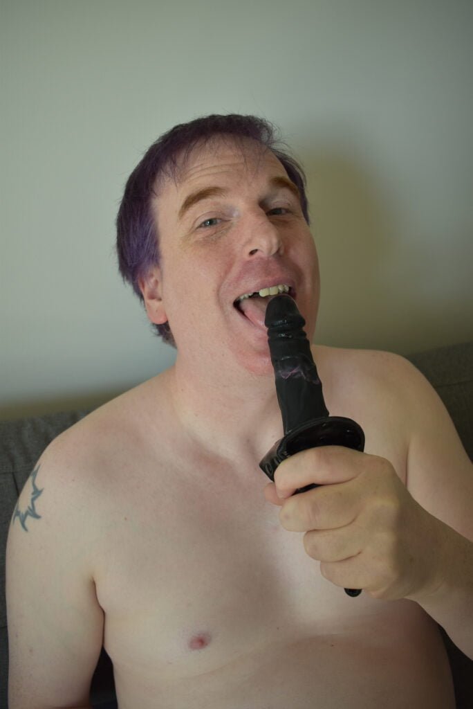 Gay submissive licking black dildo.