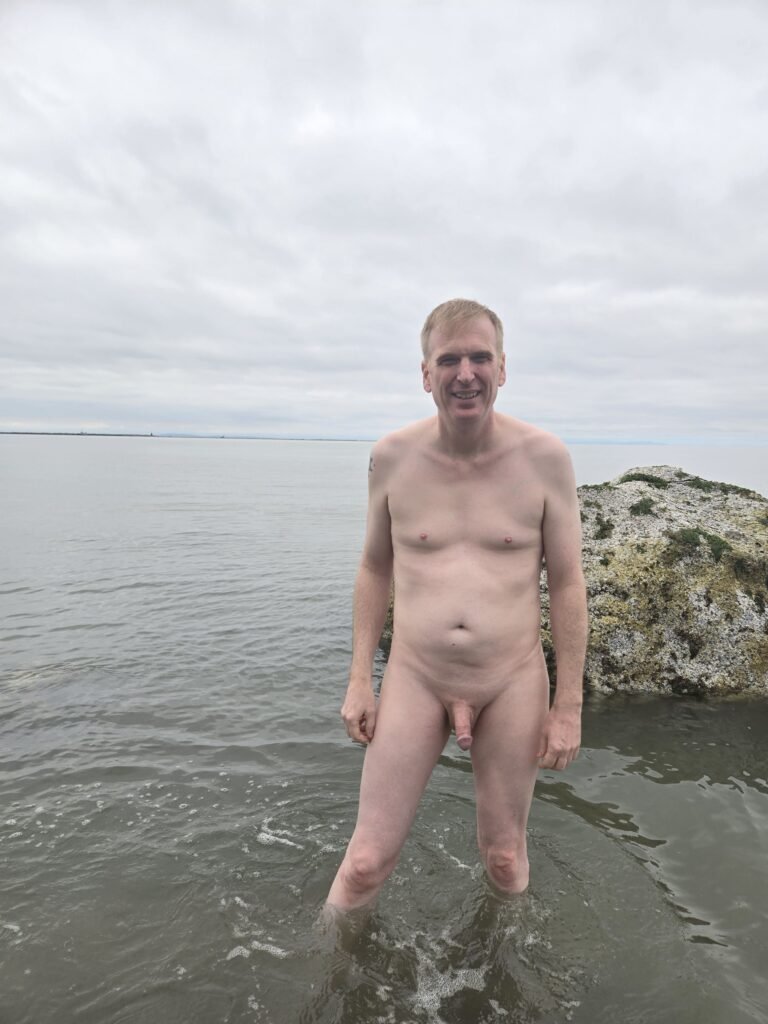 naked man standing on Wreck Beach in Vancouver.