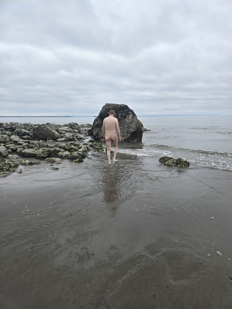 Walking naked on Wreck Beach in Vancouver on a cloudy day.