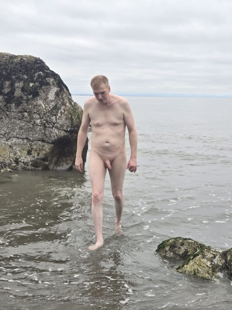 A man naked at Wreck Beach in Vancouver on a cloudy day. 