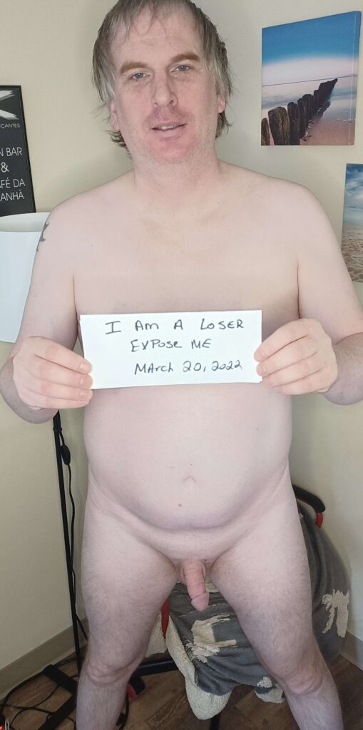 Public Humiliation Captions 11 Exposed loser standing naked holding a sign that says I am a loser, expose me.