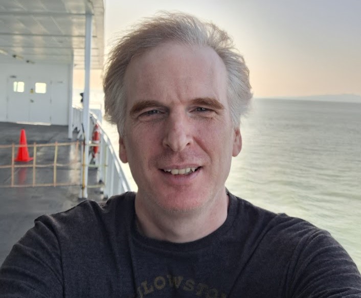 Justin Smith from Duncan, BC 3 Selfie photo of Justin Smith on BC Ferry with sunset and ocean water in the background.